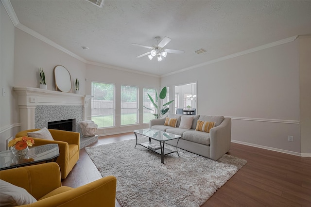 11943 Natural Bridges Ln, Sugar Land, TX 77498 - living room with wood finished floors, ceiling fan, a fireplace, crown molding, and baseboards