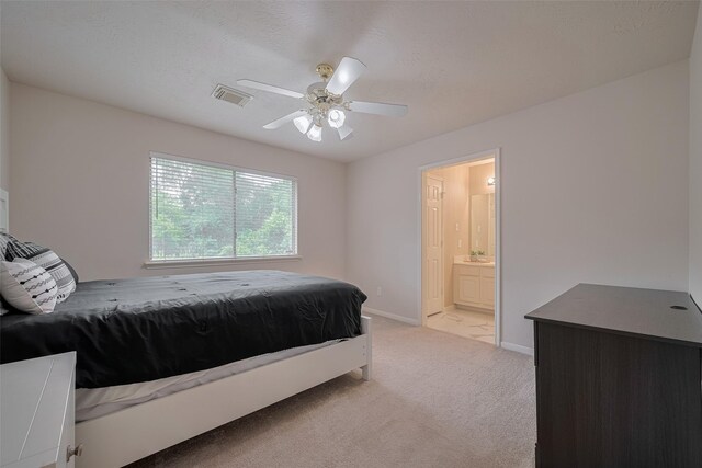 11943 Natural Bridges Ln, Sugar Land, TX 77498 - bedroom with light colored carpet, baseboards, ensuite bath, a ceiling fan, and a sink