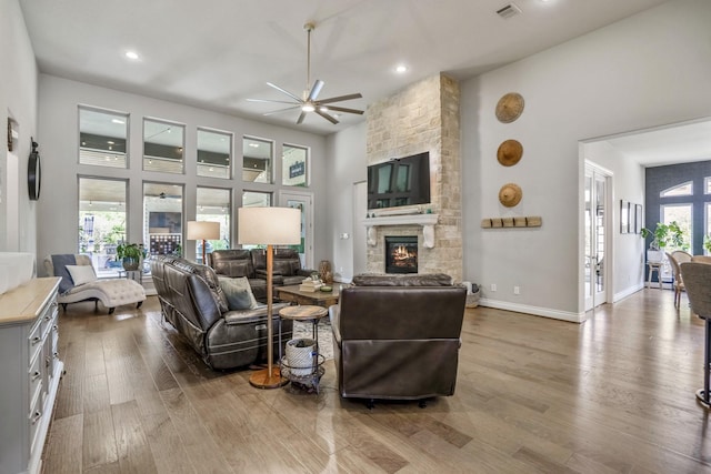 2715 Merlin Way, Katy, TX 77493 - living room featuring ceiling fan, a stone fireplace, wood finished floors, recessed lighting, and a high ceiling