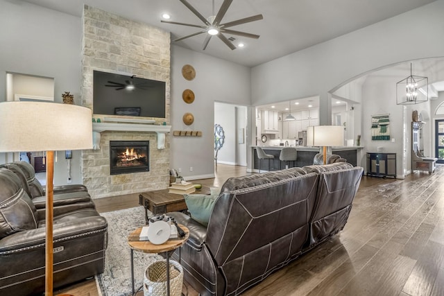 2715 Merlin Way, Katy, TX 77493 - living room with a ceiling fan, wood finished floors, high vaulted ceiling, a stone fireplace, and arched walkways