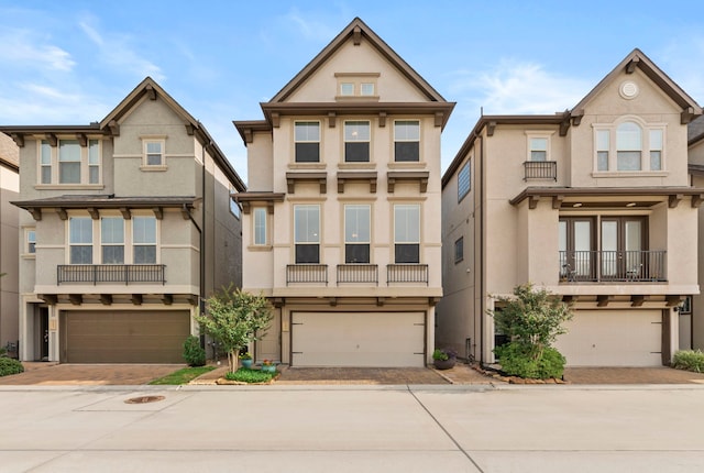 10822 Brittmoore Oaks Pl, Houston, TX 77043 - view of front facade with stucco siding, an attached garage, and decorative driveway