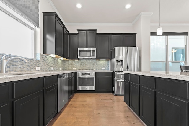 10822 Brittmoore Oaks Pl, Houston, TX 77043 - kitchen with stainless steel appliances, a sink, dark cabinets, light stone countertops, and decorative backsplash