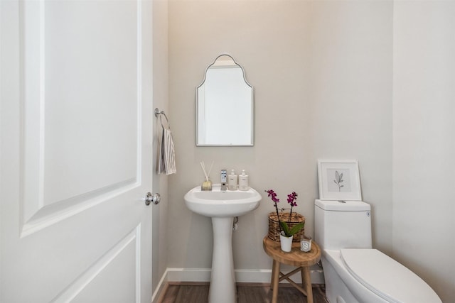 809 Burton Landing Ln, Houston, TX 77008 - half bath with toilet, baseboards, wood finished floors, and a sink