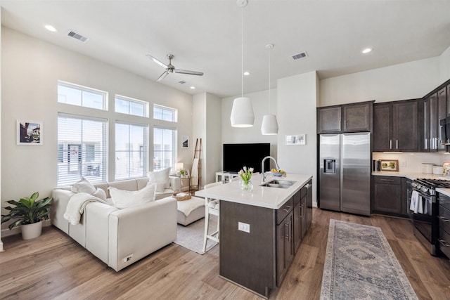 809 Burton Landing Ln, Houston, TX 77008 - kitchen with stainless steel appliances, open floor plan, a sink, dark brown cabinetry, and ceiling fan