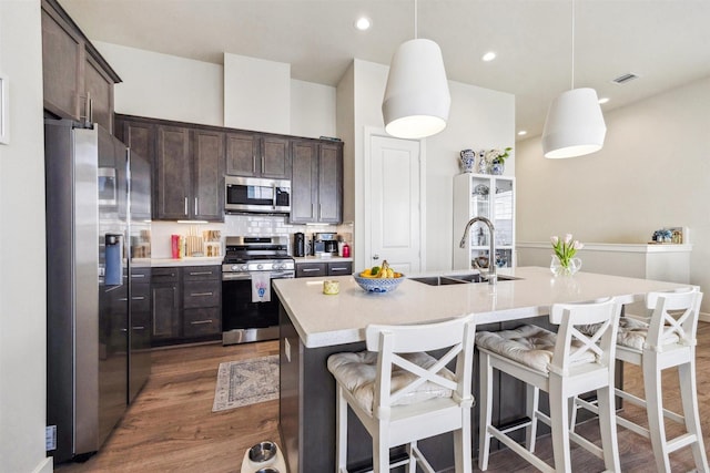 809 Burton Landing Ln, Houston, TX 77008 - kitchen with appliances with stainless steel finishes, a sink, dark wood-type flooring, dark brown cabinets, and light countertops