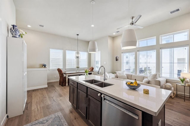 809 Burton Landing Ln, Houston, TX 77008 - kitchen with stainless steel dishwasher, a sink, dark brown cabinets, open floor plan, and light wood-style flooring