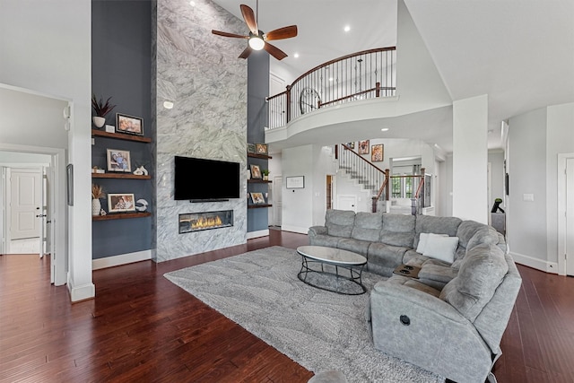 2603 Open Prairie Ln, Katy, TX 77493 - living room featuring a towering ceiling, a ceiling fan, stairway, a fireplace, and wood-type flooring