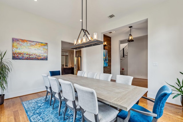 815 E 27th St, Houston, TX 77009 - dining room with baseboards, light wood-type flooring, and stairway
