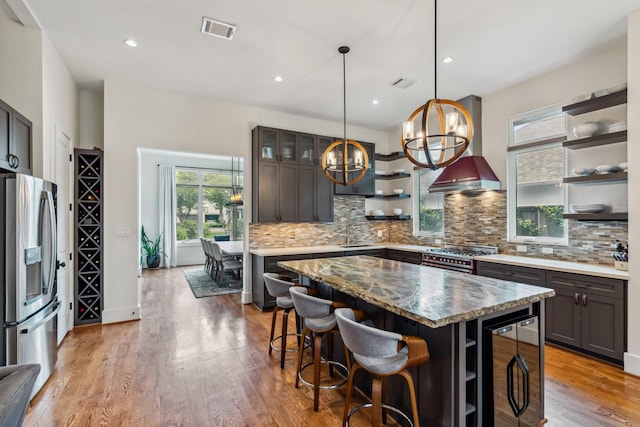 815 E 27th St, Houston, TX 77009 - kitchen with stainless steel appliances, open shelves, wine cooler, wall chimney range hood, and decorative backsplash