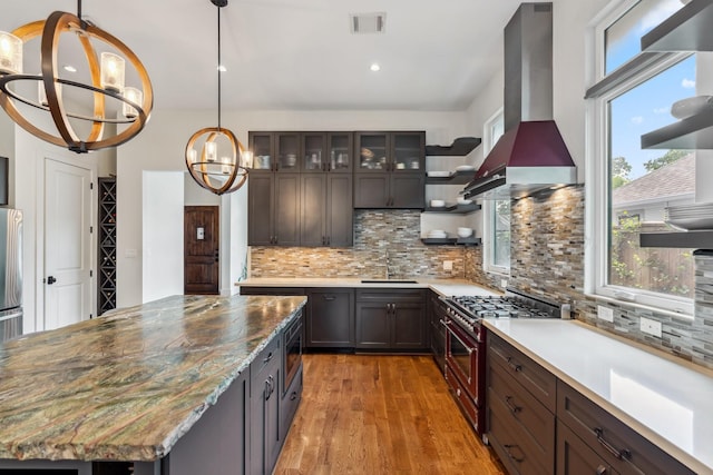 815 E 27th St, Houston, TX 77009 - kitchen featuring appliances with stainless steel finishes, a sink, light wood-type flooring, a chandelier, and backsplash
