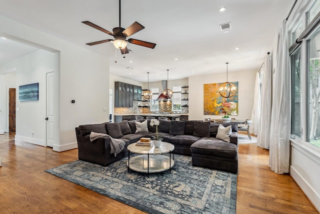 815 E 27th St, Houston, TX 77009 - living room with a chandelier, light wood finished floors, a ceiling fan, baseboards, and recessed lighting