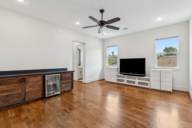 815 E 27th St, Houston, TX 77009 - unfurnished living room with wine cooler, wood finished floors, recessed lighting, a ceiling fan, and baseboards