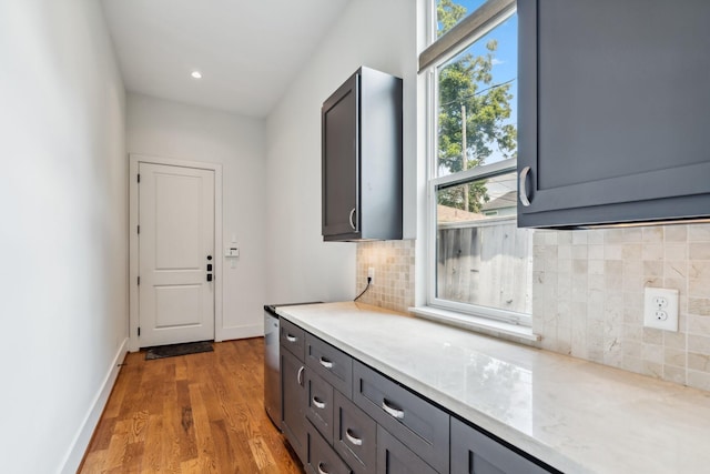 815 E 27th St, Houston, TX 77009 - interior space with light wood-type flooring, decorative backsplash, light stone counters, baseboards, and gray cabinets