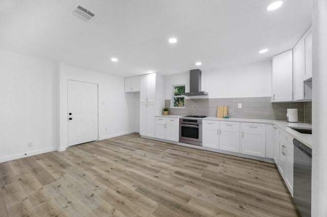 3906 Simsbrook Dr, Houston, TX 77045 - kitchen with wall chimney exhaust hood, stainless steel appliances, backsplash, white cabinets, and recessed lighting