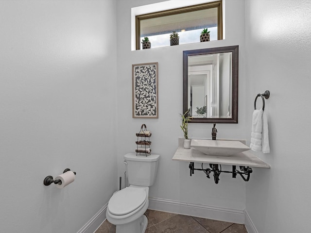 19003 Cove Manor Dr, Cypress, TX 77433 - half bathroom with toilet, baseboards, tile patterned floors, and a sink