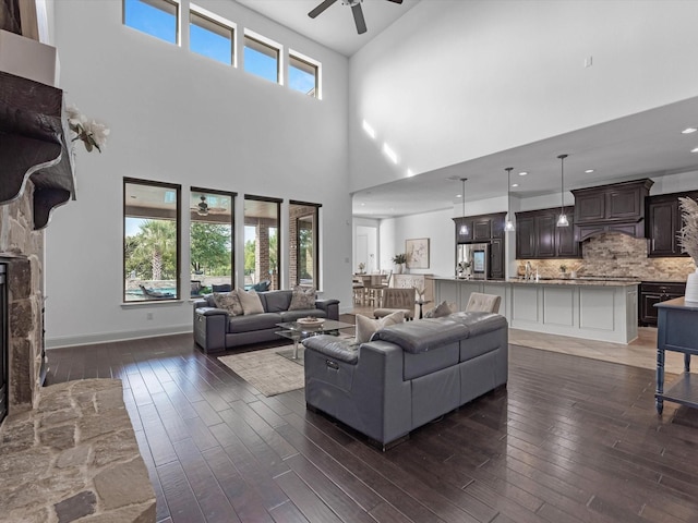 19003 Cove Manor Dr, Cypress, TX 77433 - living area featuring a ceiling fan, dark wood-style floors, a towering ceiling, and baseboards