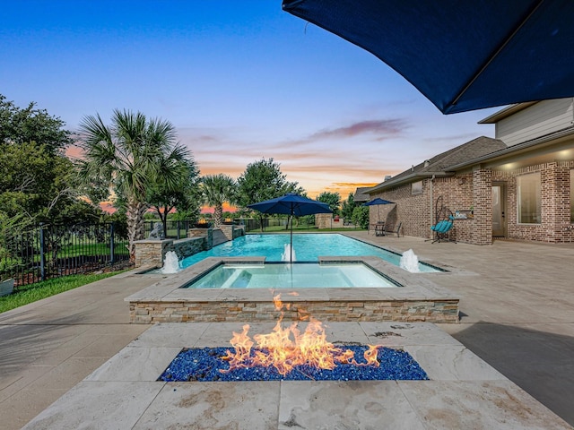 19003 Cove Manor Dr, Cypress, TX 77433 - pool at dusk featuring an in-ground hot tub, a patio area, and an outdoor fire pit
