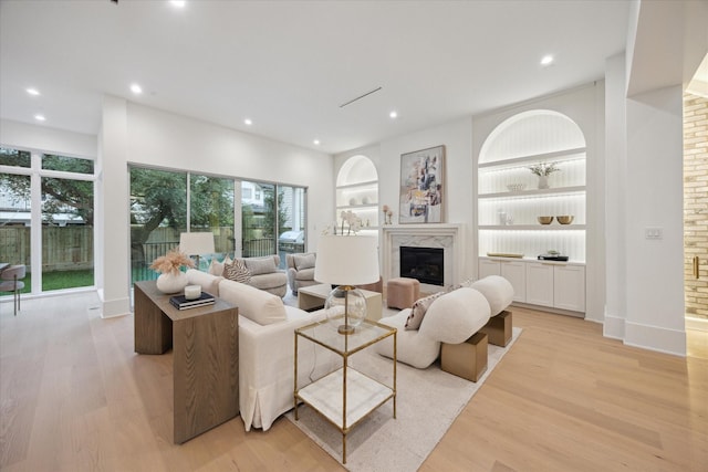 806 Holton St, Bellaire, TX 77401 - living room featuring a high end fireplace, light wood-style flooring, recessed lighting, built in shelves, and plenty of natural light