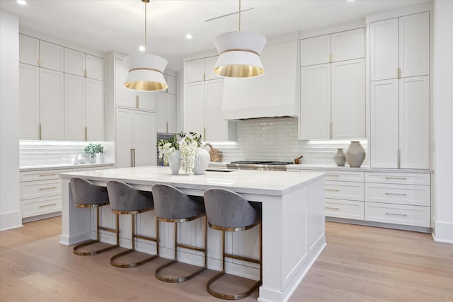 806 Holton St, Bellaire, TX 77401 - kitchen with a center island with sink, recessed lighting, light countertops, decorative backsplash, and light wood-style floors
