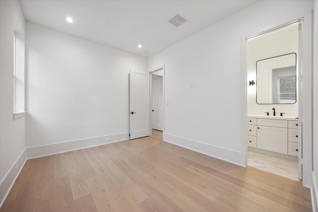 806 Holton St, Bellaire, TX 77401 - unfurnished bedroom featuring light wood-style flooring, baseboards, recessed lighting, ensuite bath, and a sink