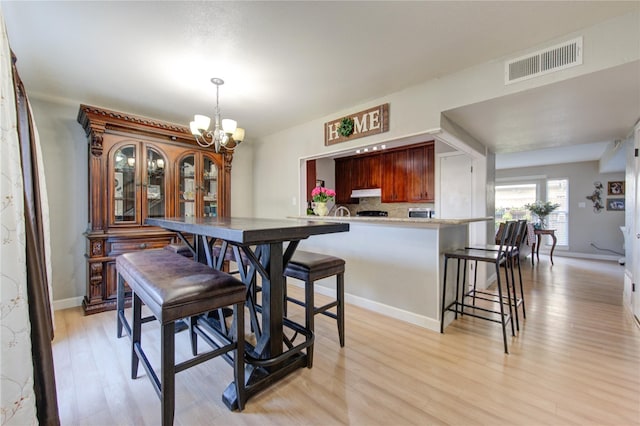 18218 Heritage Ln Unit 8218, Houston, TX 77058 - dining space with a chandelier, light wood-type flooring, and baseboards