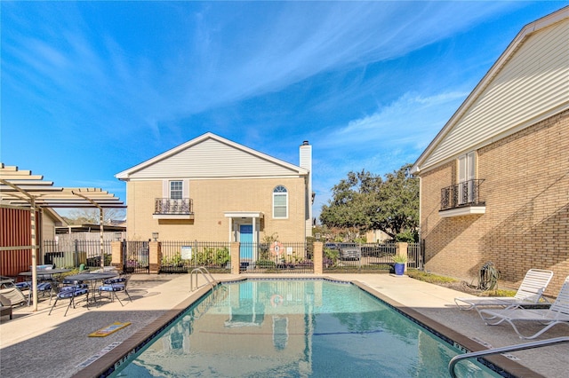 18218 Heritage Ln Unit 8218, Houston, TX 77058 - back of house featuring a community pool, a patio area, a chimney, and stucco siding