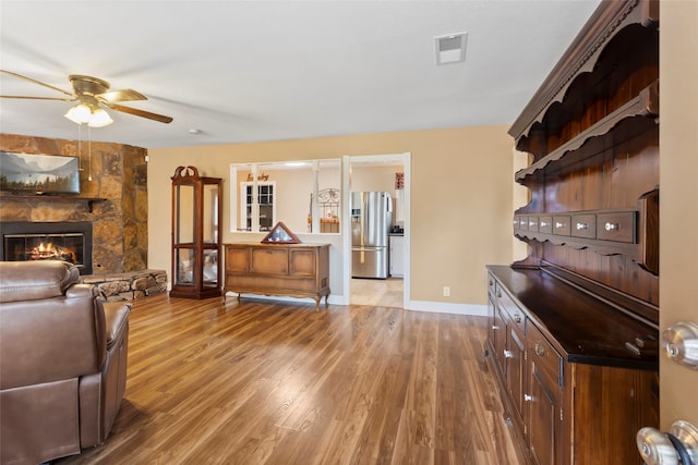 1518 14th Ave N, Texas City, TX 77590 - living area featuring a ceiling fan, light wood-type flooring, a fireplace, and baseboards