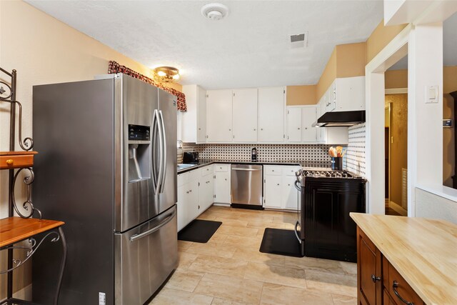 1518 14th Ave N, Texas City, TX 77590 - kitchen featuring appliances with stainless steel finishes, under cabinet range hood, decorative backsplash, and white cabinetry