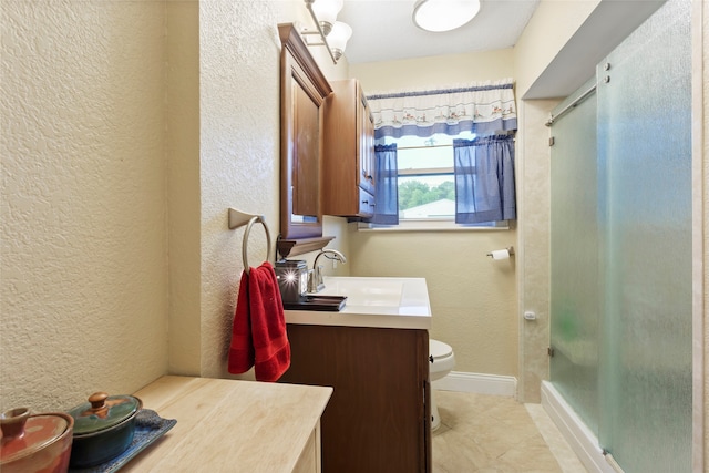 1518 14th Ave N, Texas City, TX 77590 - full bathroom featuring vanity, a textured wall, toilet, a shower with door, and tile patterned floors