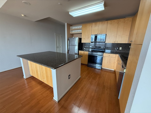 3505 Sage Rd Unit 1807, Houston, TX 77056 - kitchen featuring appliances with stainless steel finishes, light brown cabinets, dark wood finished floors, backsplash, and a center island