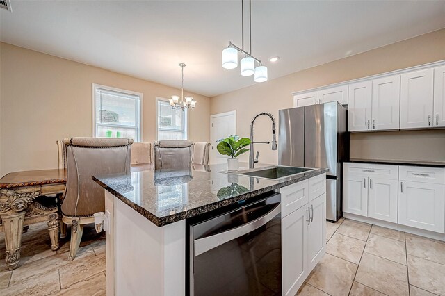 6702 Utah St, Houston, TX 77091 - kitchen featuring stainless steel appliances, a sink, a chandelier, white cabinets, and a center island with sink