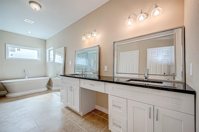 6702 Utah St, Houston, TX 77091 - bathroom with double vanity, a freestanding tub, tile patterned flooring, and baseboards