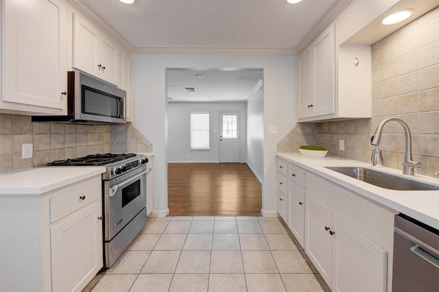 502 Enid St, Houston, TX 77009 - kitchen with stainless steel appliances, a sink, light tile patterned floors, light countertops, and recessed lighting