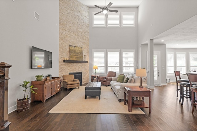 6602 Rochester Lake Loop, Katy, TX 77493 - living room featuring ceiling fan, a stone fireplace, dark wood-style flooring, baseboards, and a towering ceiling