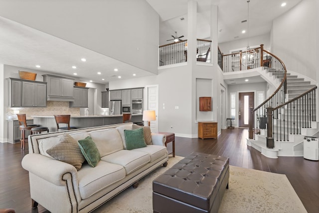6602 Rochester Lake Loop, Katy, TX 77493 - living area featuring a ceiling fan, a towering ceiling, baseboards, dark wood-type flooring, and stairway