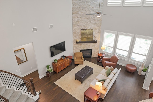 6602 Rochester Lake Loop, Katy, TX 77493 - living area featuring a towering ceiling, a stone fireplace, baseboards, dark wood-style floors, and ceiling fan