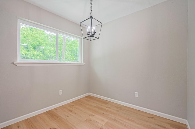 10623 Dunvegan Way, Houston, TX 77013 - empty room featuring a chandelier, baseboards, light wood-type flooring, and healthy amount of natural light