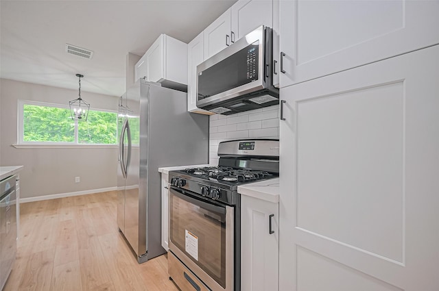 10623 Dunvegan Way, Houston, TX 77013 - kitchen featuring stainless steel appliances, light wood-type flooring, white cabinetry, baseboards, and tasteful backsplash