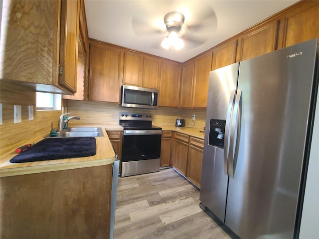 405 Wakefield Rd, Conroe, TX 77316 - kitchen featuring appliances with stainless steel finishes, a sink, light countertops, and brown cabinets