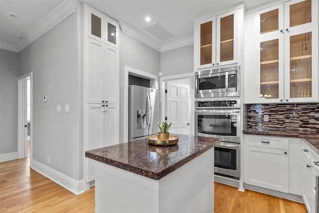 1509 Summer St, Houston, TX 77007 - kitchen featuring stainless steel appliances, crown molding, tasteful backsplash, a kitchen island, and light wood finished floors