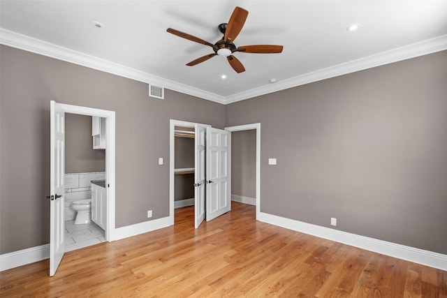 1509 Summer St, Houston, TX 77007 - unfurnished bedroom featuring crown molding, light wood finished floors, a spacious closet, ensuite bath, and baseboards