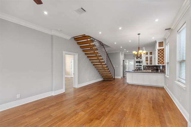 1509 Summer St, Houston, TX 77007 - unfurnished living room featuring stairway, ornamental molding, recessed lighting, a chandelier, and baseboards
