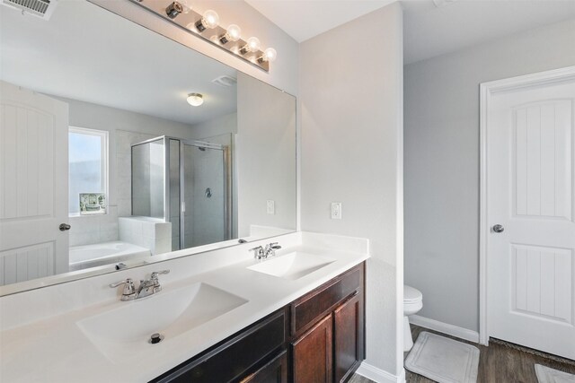 12911 Italian Cypress Trl, Houston, TX 77044 - full bath featuring double vanity, a shower stall, a garden tub, toilet, and wood finished floors