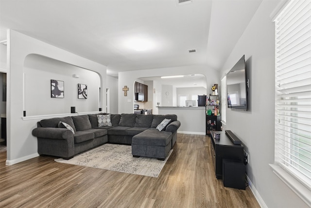 12911 Italian Cypress Trl, Houston, TX 77044 - living area with wood finished floors, arched walkways, and baseboards