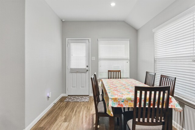 12911 Italian Cypress Trl, Houston, TX 77044 - dining space with light wood-style floors, lofted ceiling, and baseboards