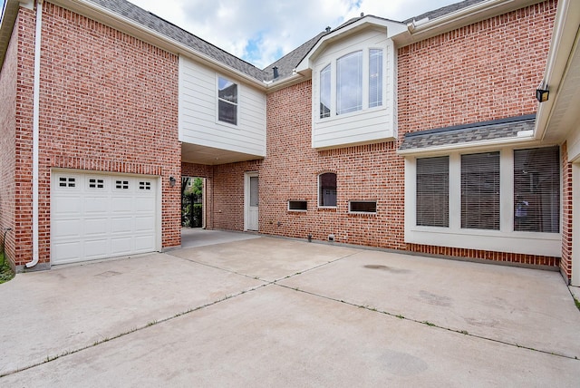 1611 Whitfield St, Sugar Land, TX 77479 - back of property with brick siding, concrete driveway, roof with shingles, and an attached garage