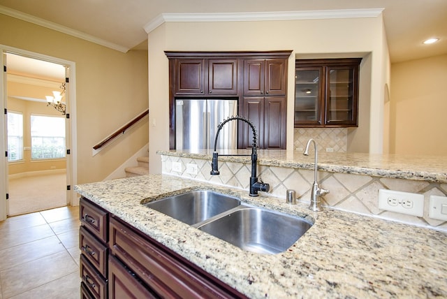 1611 Whitfield St, Sugar Land, TX 77479 - kitchen with freestanding refrigerator, a sink, backsplash, crown molding, and a chandelier