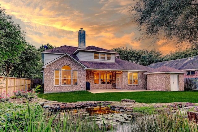2102 Ivy Cove Ct, Katy, TX 77494 - back of house at dusk with a chimney, a patio area, and brick siding