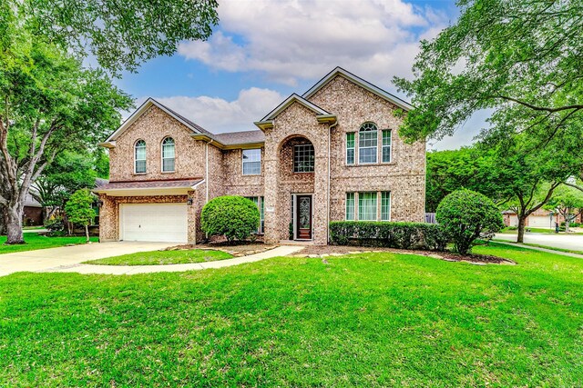 2102 Ivy Cove Ct, Katy, TX 77494 - traditional home with an attached garage, concrete driveway, a front lawn, and brick siding