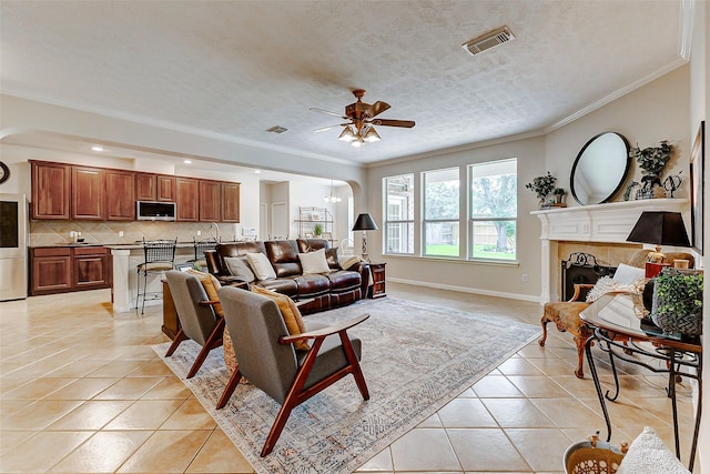 2102 Ivy Cove Ct, Katy, TX 77494 - living area featuring light tile patterned flooring, a ceiling fan, ornamental molding, a tile fireplace, and baseboards